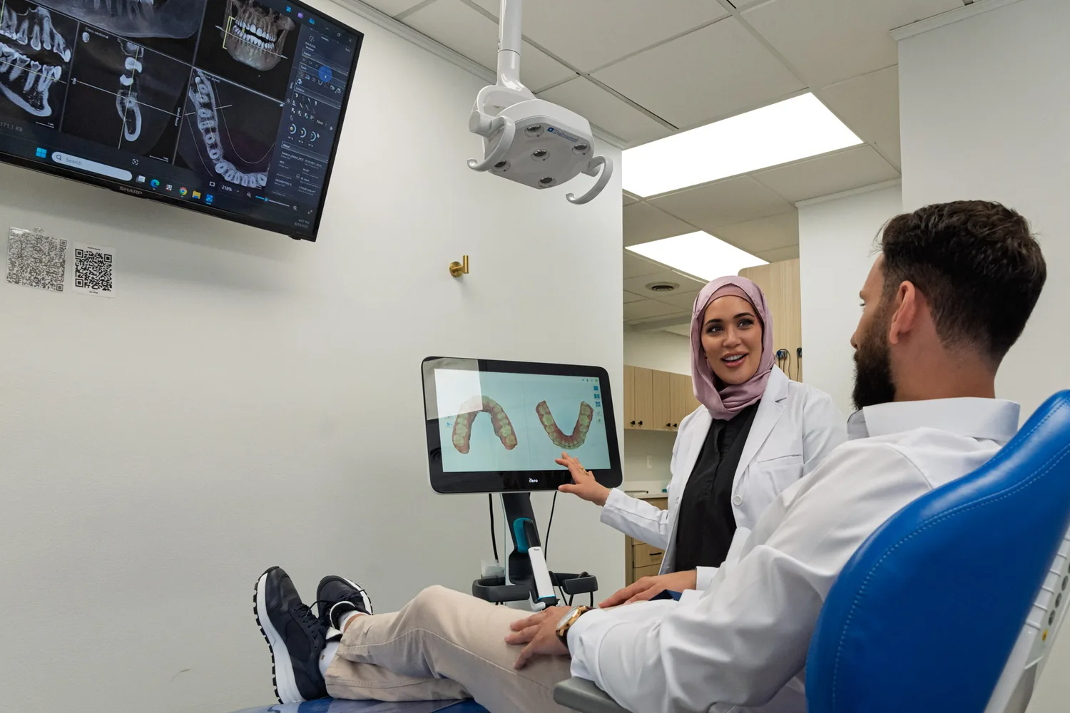 A SmilePro Dental dentist reviewing a 3D scan on screen with a patient