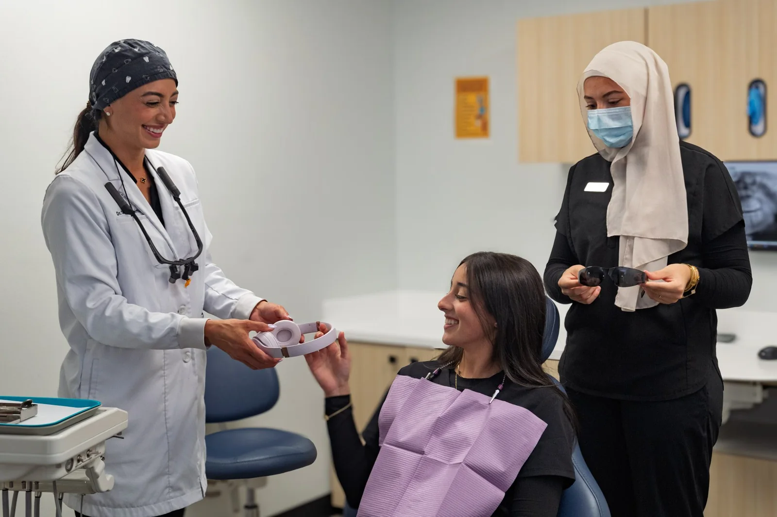 A SmilePro Dental dentist and assistant going over a patient's treatment with her at the chair