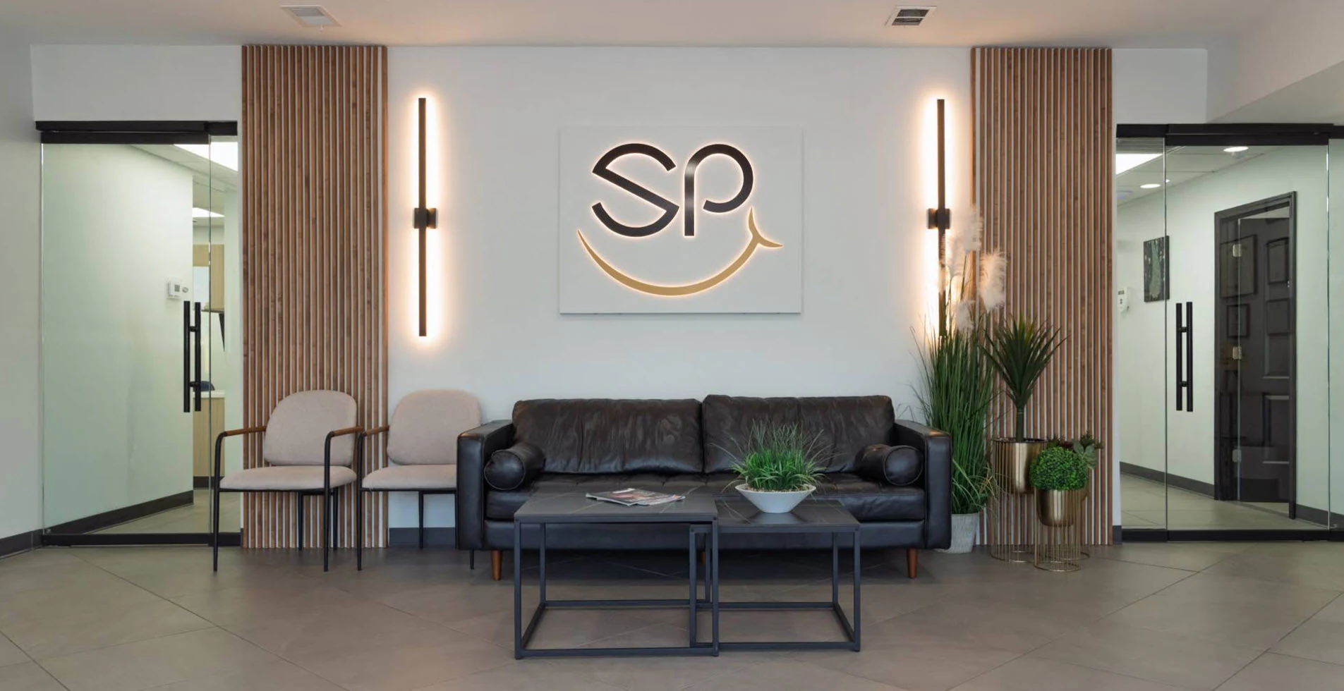 The SmilePro Dental reception area in Dearborn Heights, with the illuminated SP logo above the waiting-room sofa