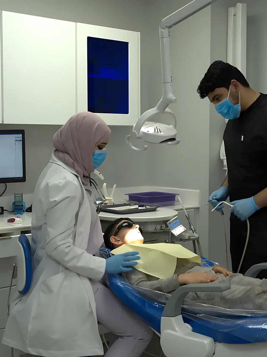 A SmilePro Dental clinician and assistant carrying out a procedure under sterile drapes in the operatory