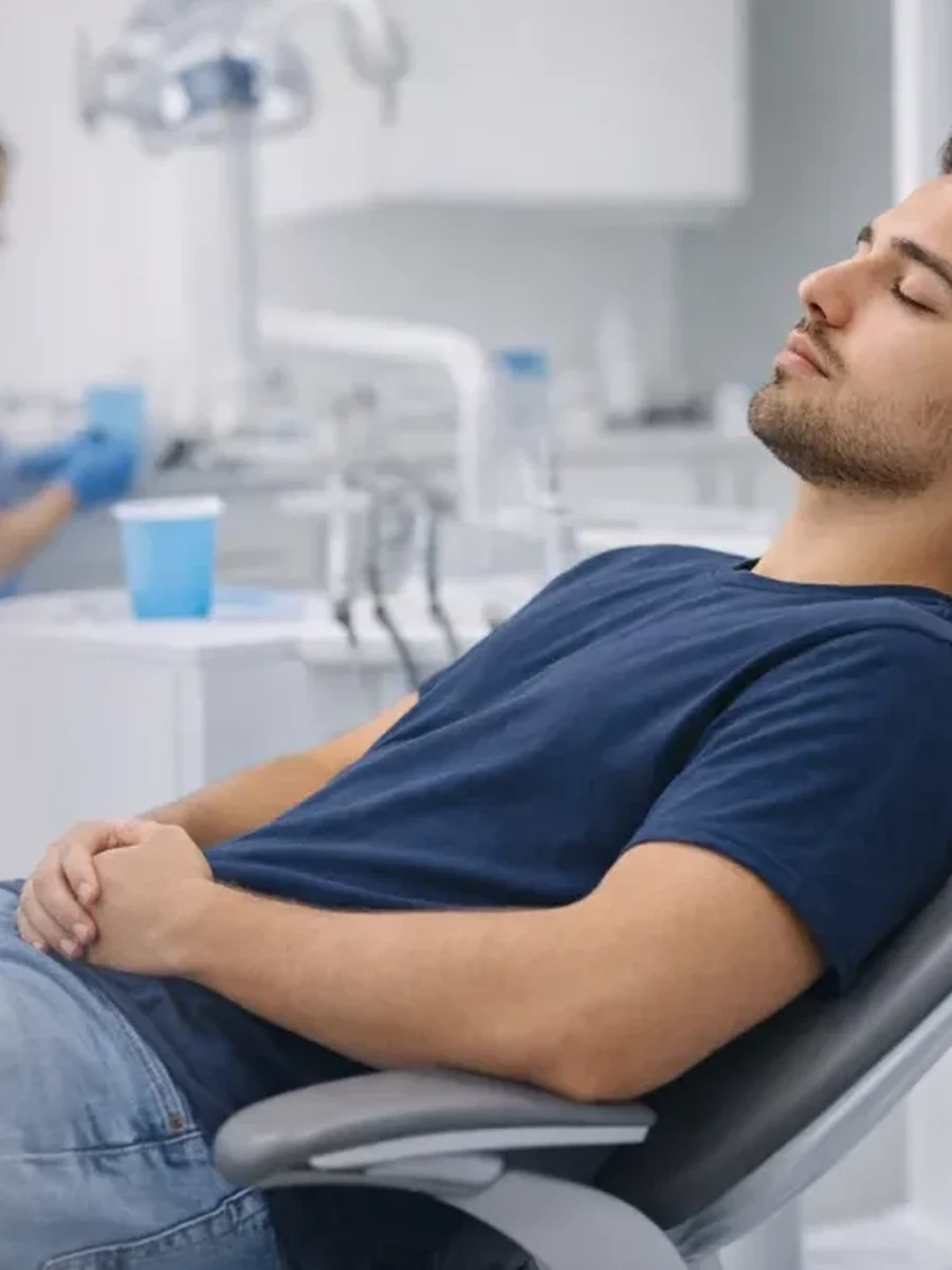 A patient resting comfortably in the chair under sedation