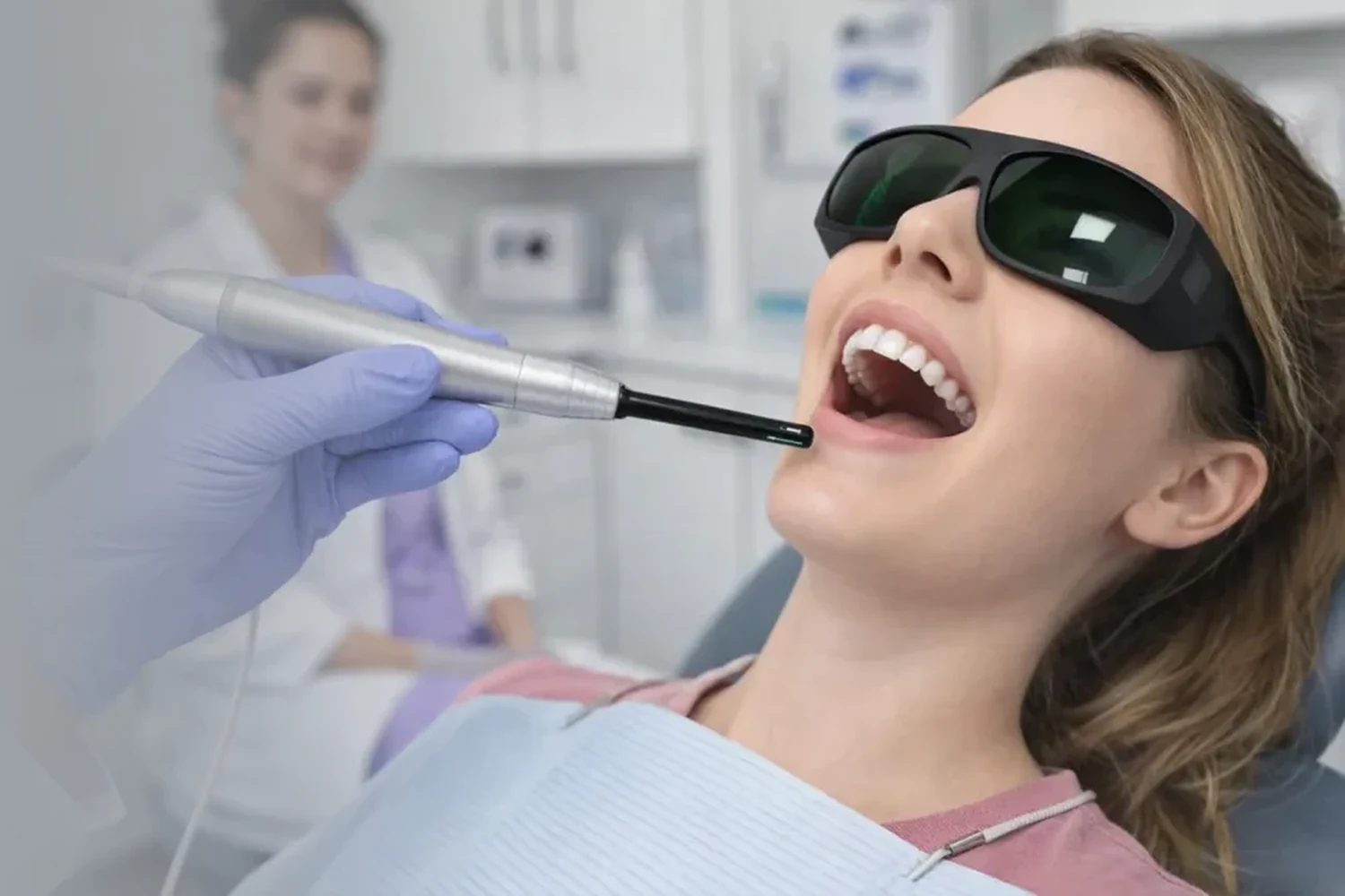 A patient in protective eyewear during laser dentistry treatment