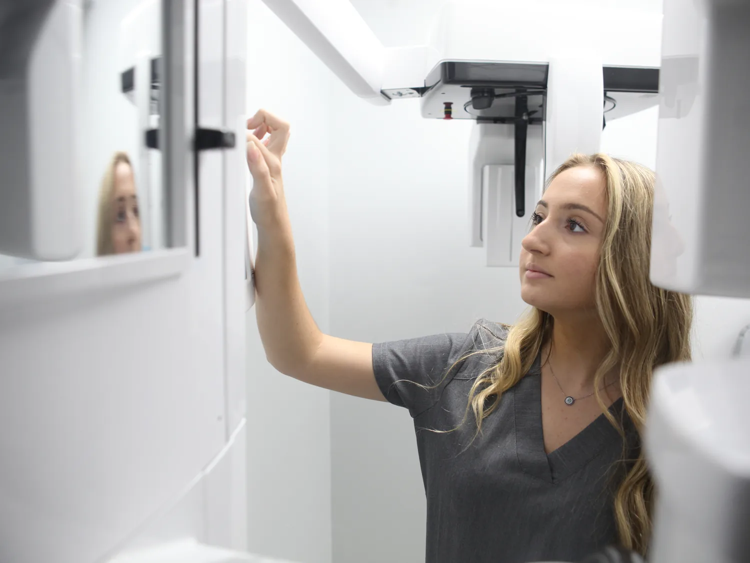 A SmilePro Dental team member positioning a patient for a panoramic X-ray