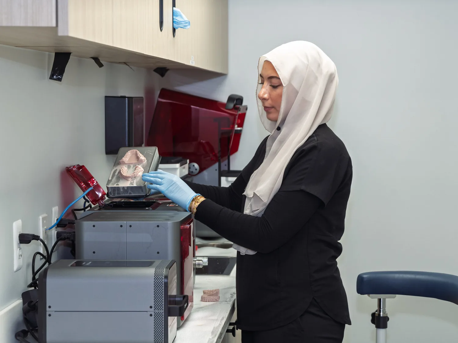 A SmilePro Dental team member operating the in-house 3D printer